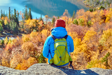 Backpacker man hiking at Artist's Bluff in autumn. View of Echo Lake. Fall colours in Franconia...