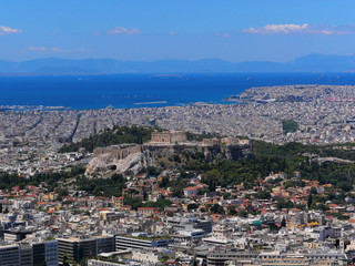 Greece, Athens panoramic view with parthenon temple on acropolis hill, Plaka old neighborhood and Saronic golf on the distant background
