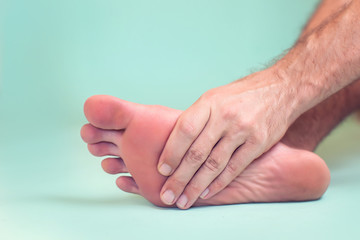 Fototapeta premium Man feels strong foot pain. People, healthcare and medicine concept