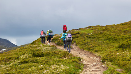 Obraz premium The group of hikers walking in mountains
