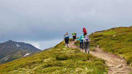 Fototapeta na wymiar The group of hikers walking in mountains