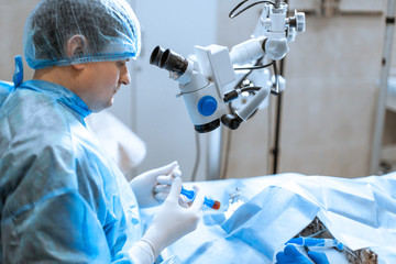 Naklejka na ściany i meble Veterinary ophthalmologist do surgery on dog injured eye