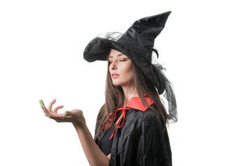 Happy gothic young woman in witch halloween costume with hat standing over white background