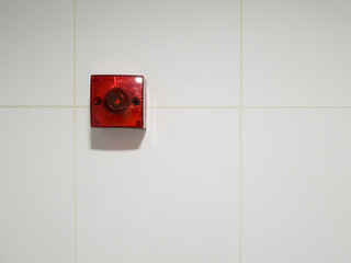 Square red warning alarm sign on tiles