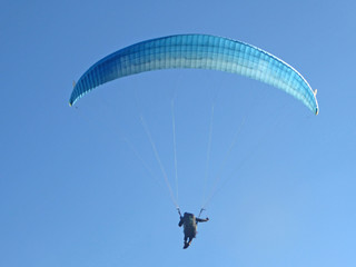 paraglider flying blue wing