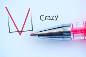 check mark on the questionnaire and the inscription - Crazy