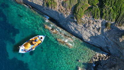 Fototapeta na wymiar Aerial top view photo of traditional fishing boat in island of Skiathos, Sporades, Greece