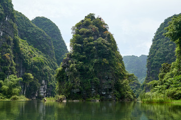 Karst mountains, tropical forest and river in Trang An, Tam Coc, Ninh Binh, Vietnam. - obrazy, fototapety, plakaty