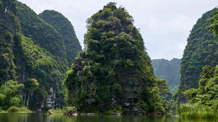 Obraz premium Beautiful landscape with river, mountains and tropical forest in Trang An, Tam Coc, Ninh Binh, Vietnam.