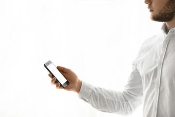 Man holding smart phone with green screen.