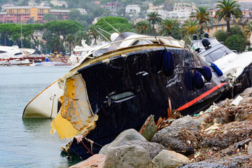 Barca distrutta da una forte mareggiata e incastrata sugli scogli