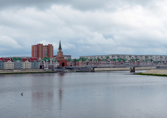 city street with a bridge over the river temples and churches on a summer day