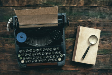 Old typewriter on a writer wooden desk background with copy space.