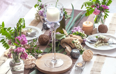 Beautifully elegant decorated table for holiday - wedding or valentine day with modern cutlery, bow, glass, candle and gift