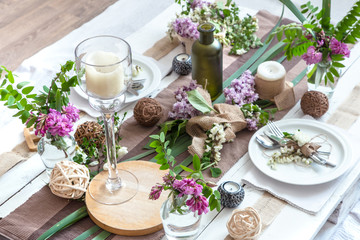 Beautifully elegant decorated table for holiday - wedding or valentine day with modern cutlery, bow, glass, candle and gift