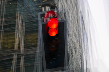 Traffic lights multiple exposure image. Traffic light showing red against of modern office block building. Business and modern life concept.  