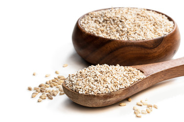 Barley groats in wooden bowl isolated on white