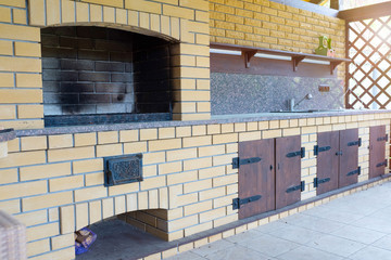 An outdoor fireplace for meals and barbeque made of bricks in the backyard.