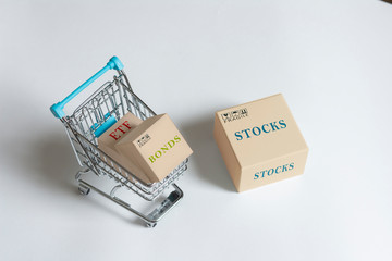 Paper boxes of financial instruments. stocks, bonds,ETFs, in shopping cart