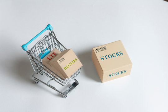 Paper boxes of financial instruments. stocks, bonds,ETFs, in shopping cart