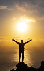 silhouette achievements successful arm up man is on top of hill celebrating success with sunrise...