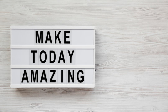 'Make today amazing' words on a modern board on a white wooden surface. From above, overhead, flat lay, top view. Copy space.