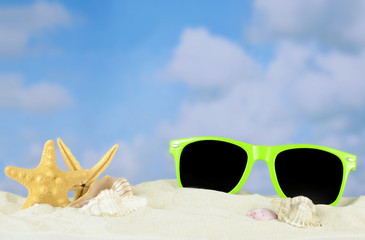 Summertime image of a beach scene on sand with a blue sky that has puffy white clouds in the...