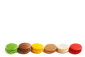 Macarons isolated on white background. Colored macaroons lined up in a row. On top of the copy space.