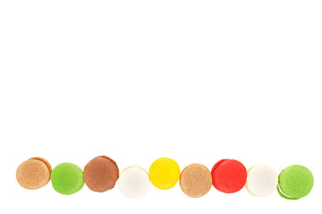 Macarons isolated on white background. Colored macaroons lined up in a row. Top view, save space.