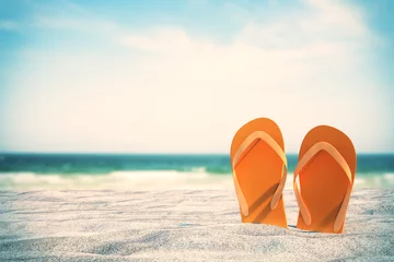 Fotobehang Oranje teenslippers op het strand © Who is Danny