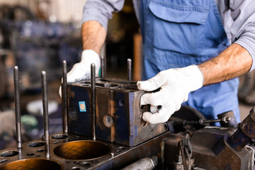 Mechanic opened the locking valve mechanism. Disassemble engine block vehicle. Old motor capital repair. Car service concept