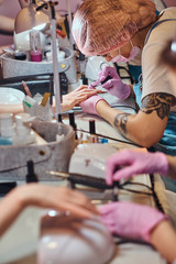 Very busy manicure studio with a lot of working staff and clients.
