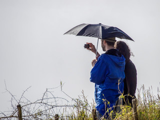 Pärchen mit Regenschirm macht ein Foto von den Viktoriafällen