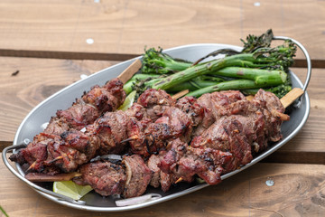 Grilled lamb meat kebabs with green broccolini