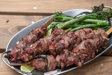 Grilled lamb meat kebabs with green broccolini