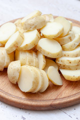 sliced boiled potatoes on the kitchen board. ingredient for the dish.