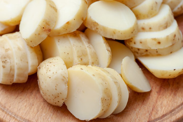 sliced boiled potatoes on the kitchen board. ingredient for the dish.