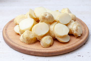 sliced boiled potatoes on the kitchen board. ingredient for the dish.