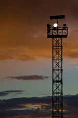 Silhouette mast lighting against the evening sky