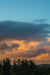 Landscape with dramatic light - beautiful golden sunset with saturated sky and clouds.