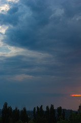 Landscape with dramatic light - beautiful golden sunset with saturated sky and clouds.
