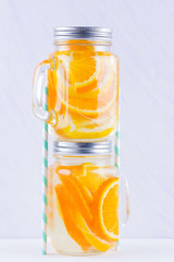 Infused water with fruits on white background. Mug delicious refreshing drink of mix fruits on white background. Iced summer drink in mason jar. Minimalism