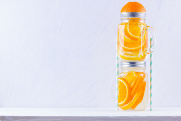 Infused water with fruits on white background. Mug delicious refreshing drink of mix fruits on white background. Iced summer drink in mason jar. Minimalism