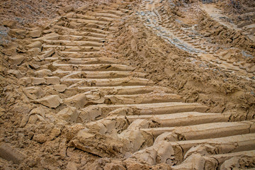 excavator tire tracks in the sand; structured background