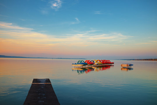 Sunset over lake Balaton with pedalos anda pier in Hungary