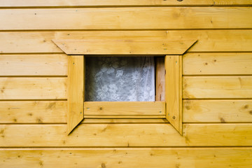 Window on the yellow wooden building facade in countryside, open window in the street