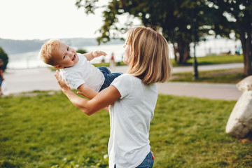 Fototapeta premium Family in a summer park. Mother in a white t-shirt. Cute little boy