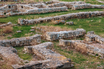 Fototapeta na wymiar Stone ruins of ancient city buildings architecture in green grass, archeology and old civilization