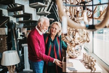 Senior couple in home lighting store shoosing shandelier for their home