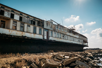 Old abandoned rusted ship aground after shipwreck accident in coast on sand beach